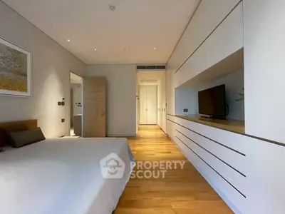 Modern bedroom with sleek built-in storage and wooden flooring