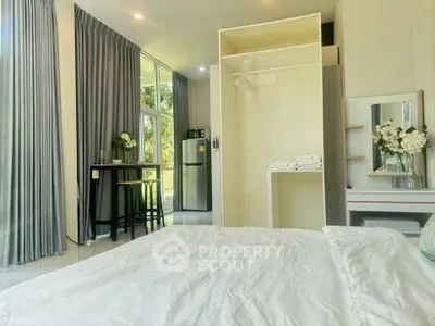 Bright modern bedroom with open closet and kitchenette in a stylish apartment
