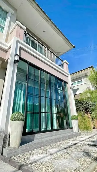 Modern two-story house with large glass windows and elegant exterior design.