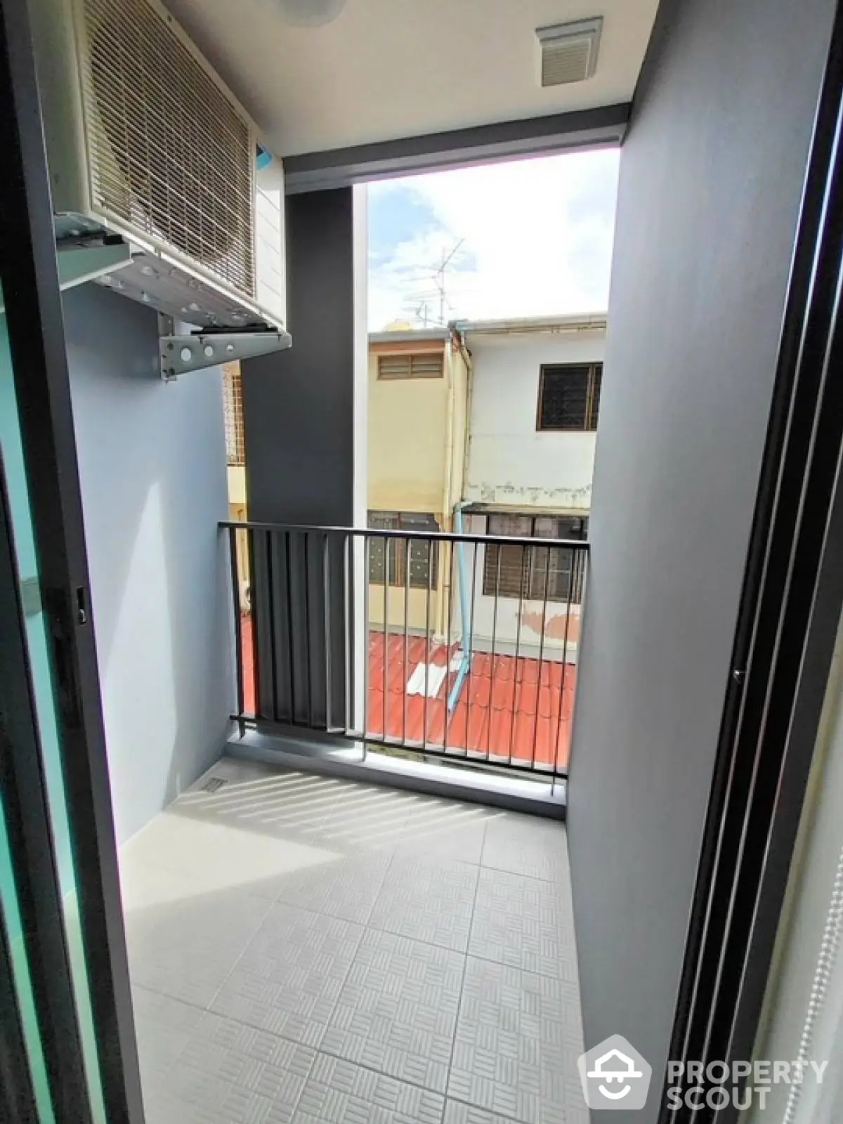 Compact balcony with air conditioning unit and urban view