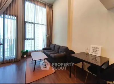 Spacious living room with high ceilings and large windows in modern apartment.