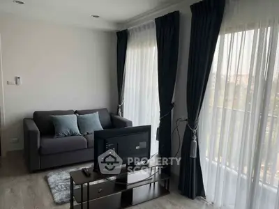 Cozy living room with modern decor and large windows offering natural light.