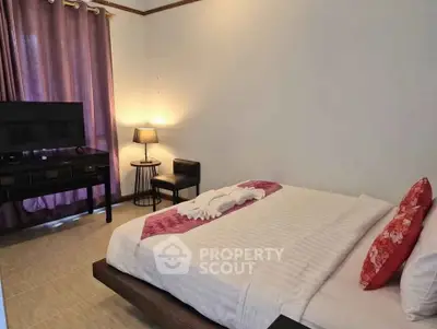 Cozy bedroom with modern decor, featuring a stylish bed, TV, and ambient lighting for a relaxing atmosphere.