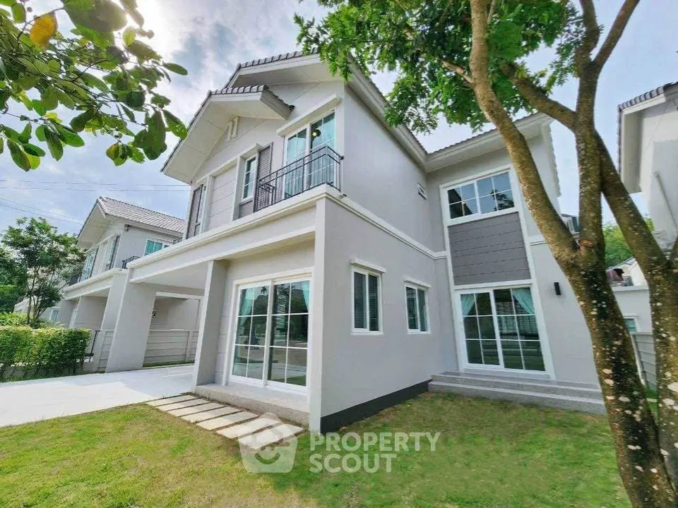 Modern two-story house with lush garden and large windows