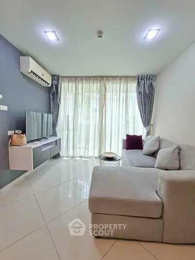 Modern living room with sleek design, featuring a cozy sectional sofa and large windows for natural light.