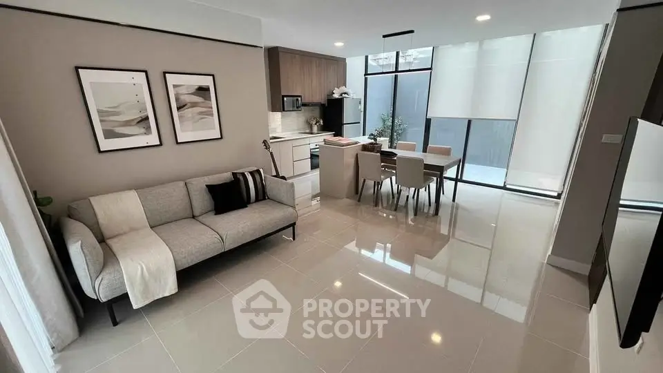 Modern open-plan living room and kitchen with sleek design and natural light