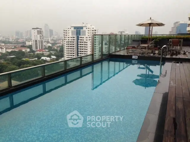Luxurious rooftop pool with stunning city views and modern amenities in a high-rise building.
