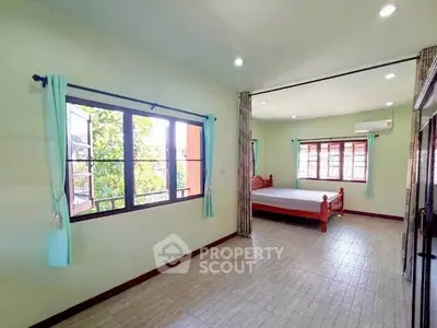 Spacious bedroom with large windows and natural light in a modern home.