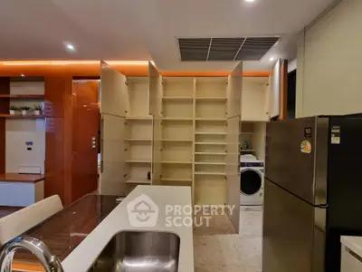 Modern kitchen with open cabinets and built-in washing machine, featuring sleek design and ample storage.