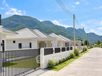 Modern suburban homes with mountain views and clear blue skies.