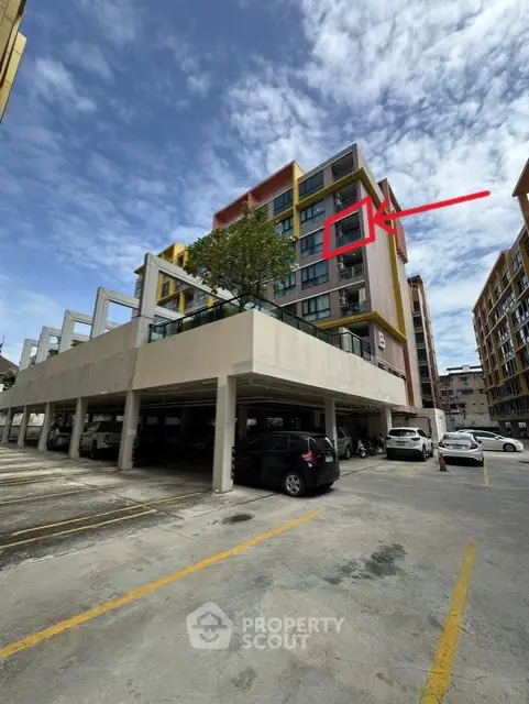 Modern apartment building with parking area and clear blue sky