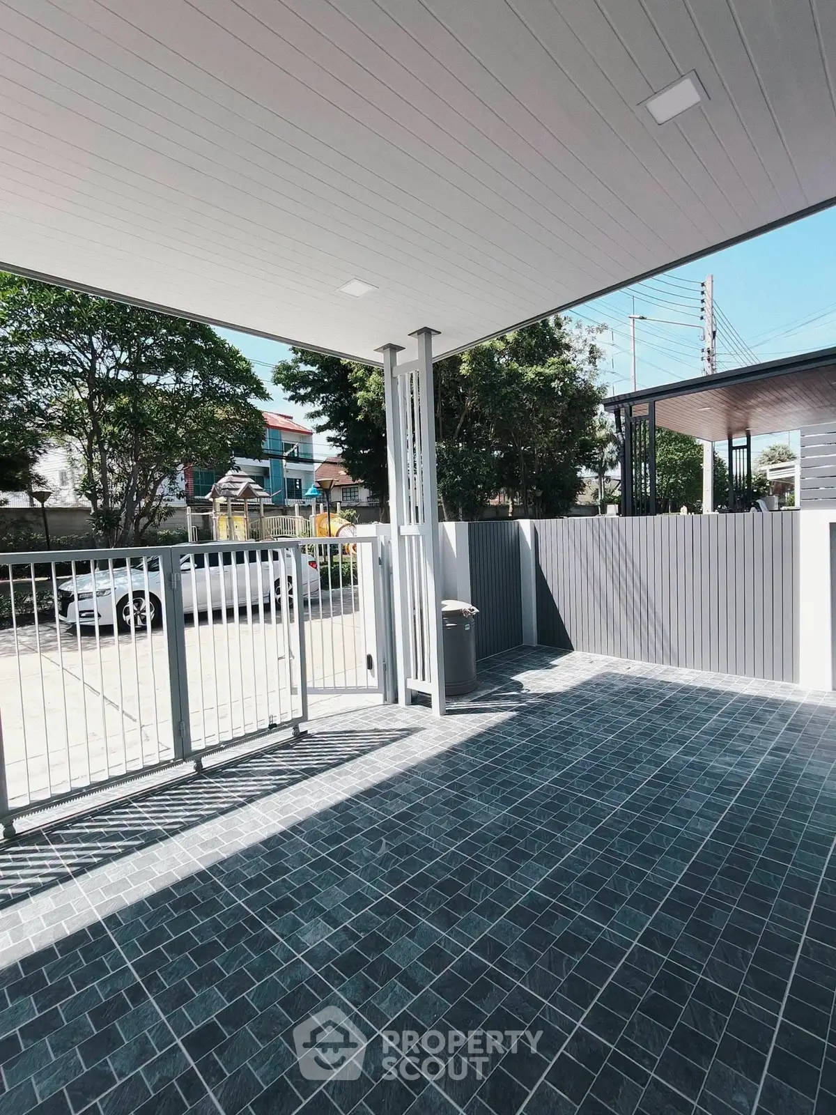 Spacious modern outdoor parking area with sleek tiled flooring and secure gated entrance.