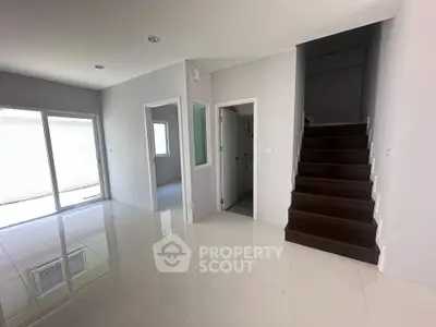 Spacious modern interior with sleek staircase and glossy tiled floors, perfect for contemporary living.