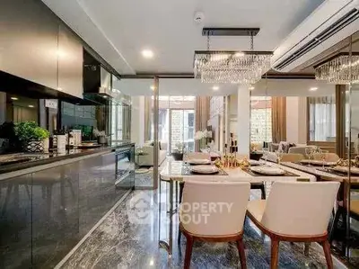 Luxurious open-plan kitchen and dining area with modern decor and elegant lighting.
