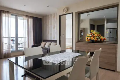 Elegant modern living room with dining area and balcony view in a stylish apartment.
