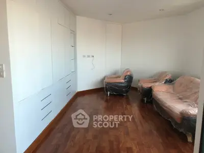 Spacious living room with hardwood floors and modern furniture in a minimalist design.