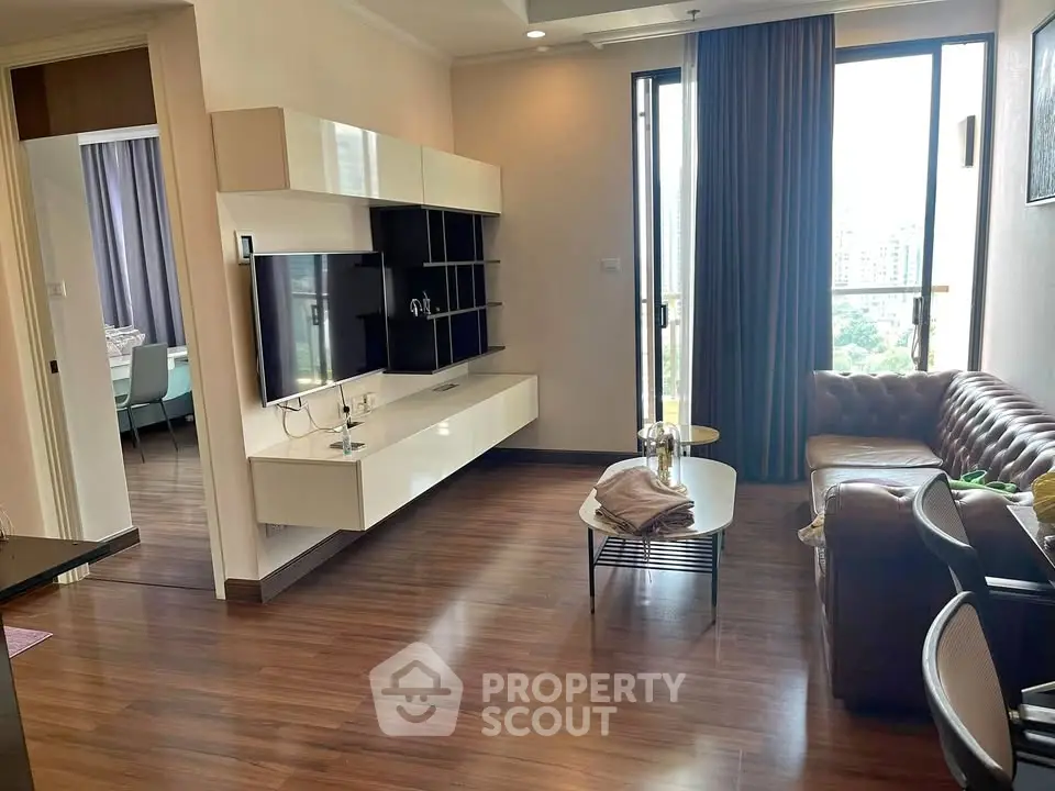 Modern living room with sleek furniture and large windows offering a city view, perfect for urban living.