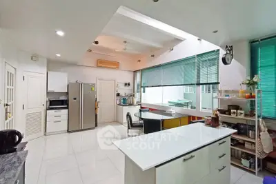 Spacious modern kitchen with sleek design and ample natural light, featuring stainless steel appliances and open layout.