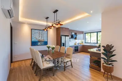 Spacious modern kitchen and dining area with elegant wooden flooring and stylish lighting.