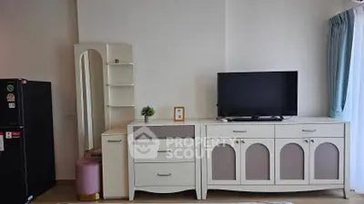 Modern living room with stylish white furniture and flat-screen TV, perfect for cozy relaxation.