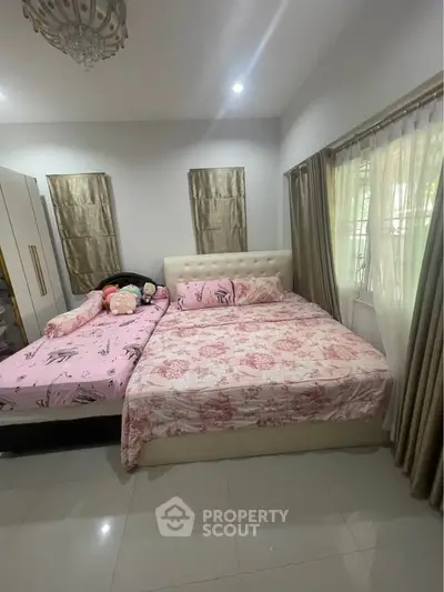 Spacious bedroom with elegant decor and large windows for natural light.