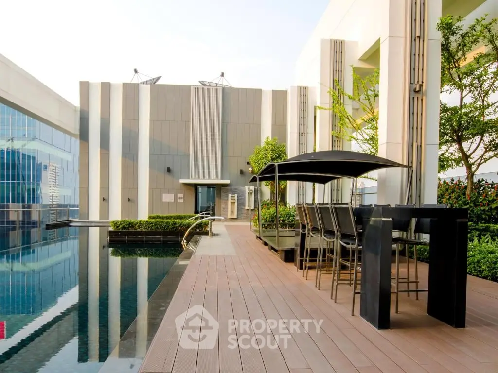 Luxurious rooftop pool area with modern seating and lush greenery