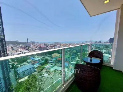 Stunning high-rise balcony with panoramic city and ocean views, perfect for relaxation.