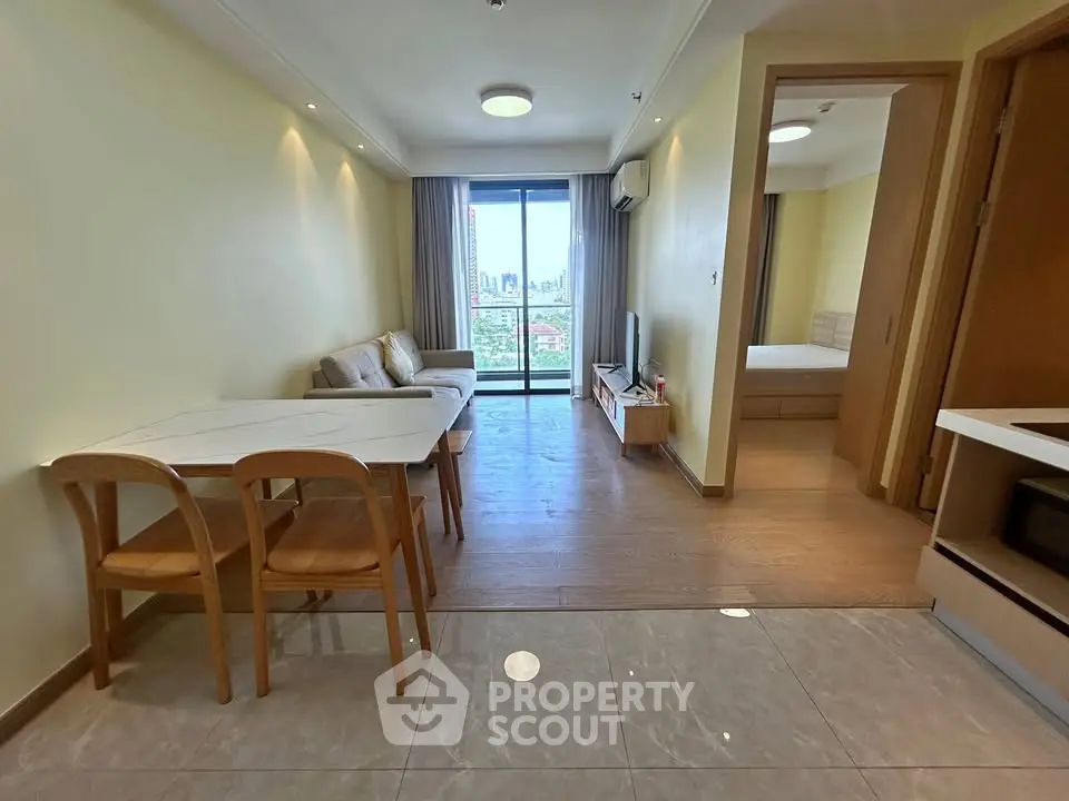 Modern living room with open layout and city view balcony in a stylish apartment.