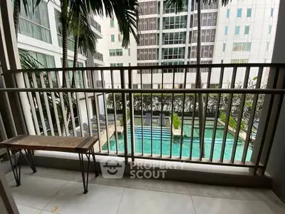 Spacious balcony with pool view in modern apartment complex