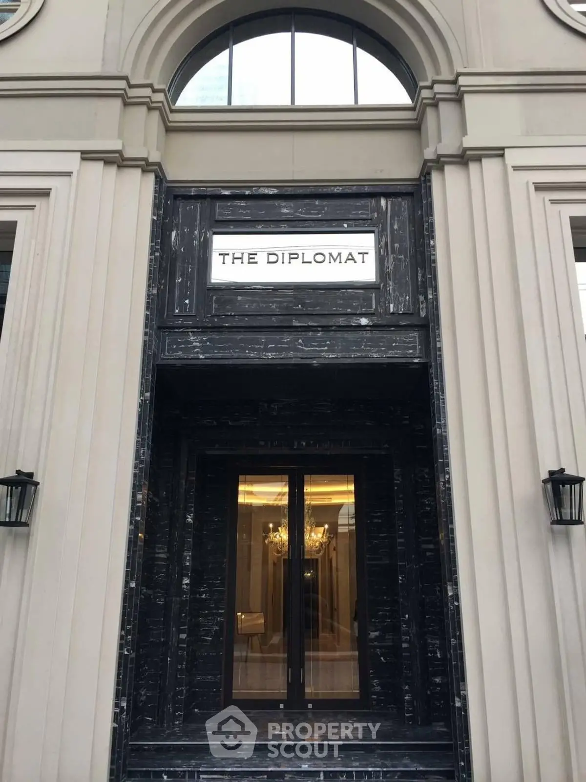 Elegant building entrance with classic architectural design and chandelier view.