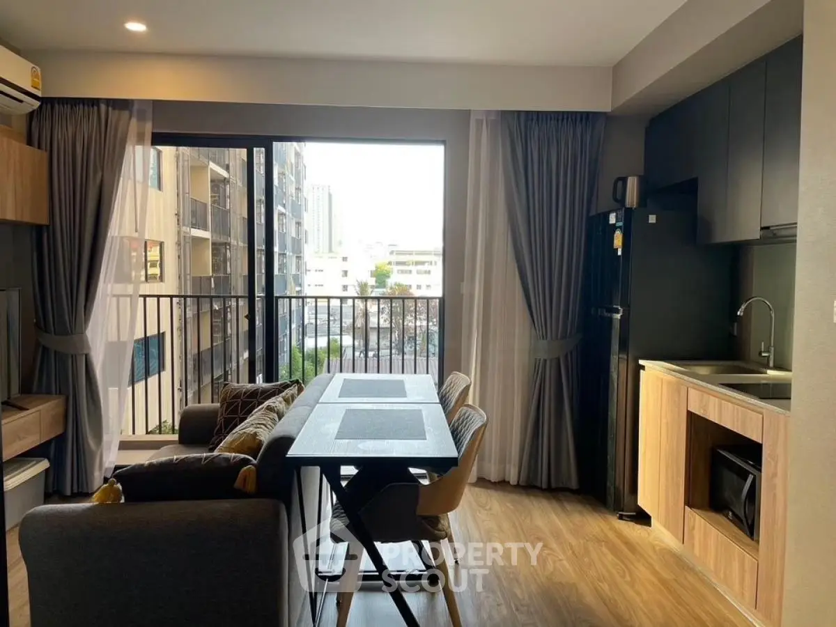 Modern open-plan living room with balcony view in urban apartment