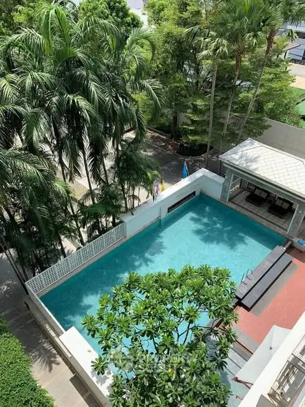 Luxurious residential pool area with lush greenery and modern design.