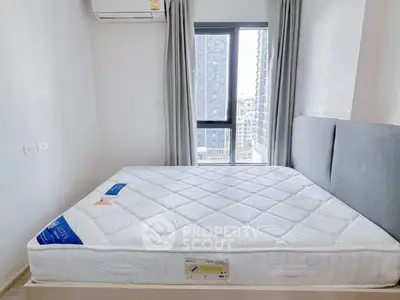 Modern bedroom with large window and air conditioning unit, offering city views.