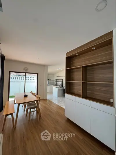 Spacious dining area with wooden flooring and modern open kitchen design