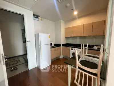 Modern kitchen with wooden cabinets, fridge, and washing machine in sleek apartment