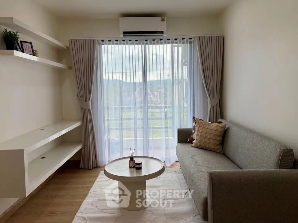 Modern living room with stylish sofa, coffee table, and large window offering scenic view.