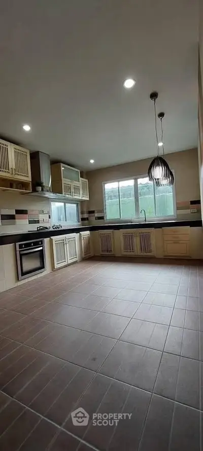 Spacious kitchen with modern fixtures and large window for natural light.