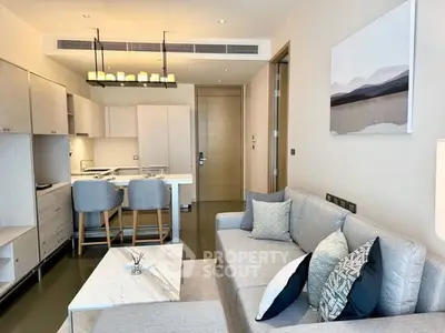 Modern living room with open kitchen, stylish decor, and cozy seating area.