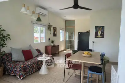 Charming living room with modern decor, vibrant sofa, dining area, and natural light.