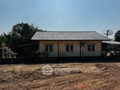 Charming single-story house with a tiled roof and spacious yard, perfect for serene living.