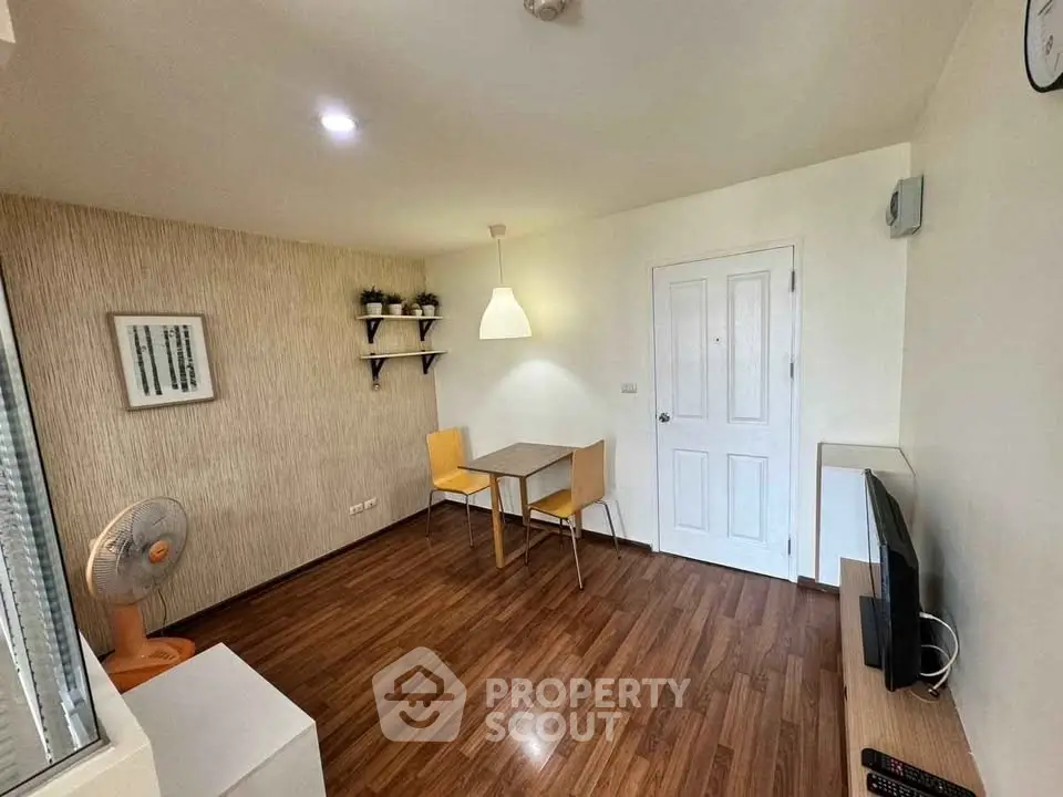 Cozy living room with wooden flooring, modern decor, and dining area.
