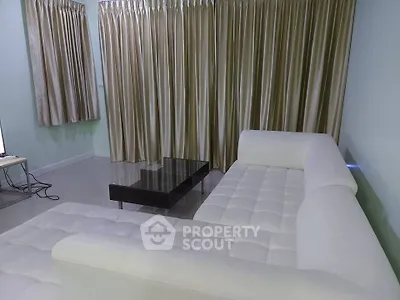 Modern living room with white sectional sofa and elegant curtains
