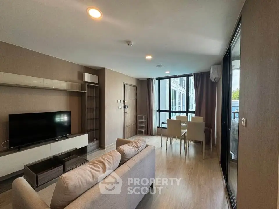 Modern living room with sleek furniture and large windows in a contemporary apartment.