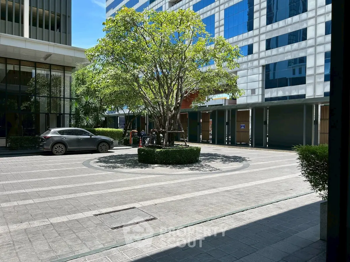 Modern office building with sleek glass facade and landscaped courtyard.