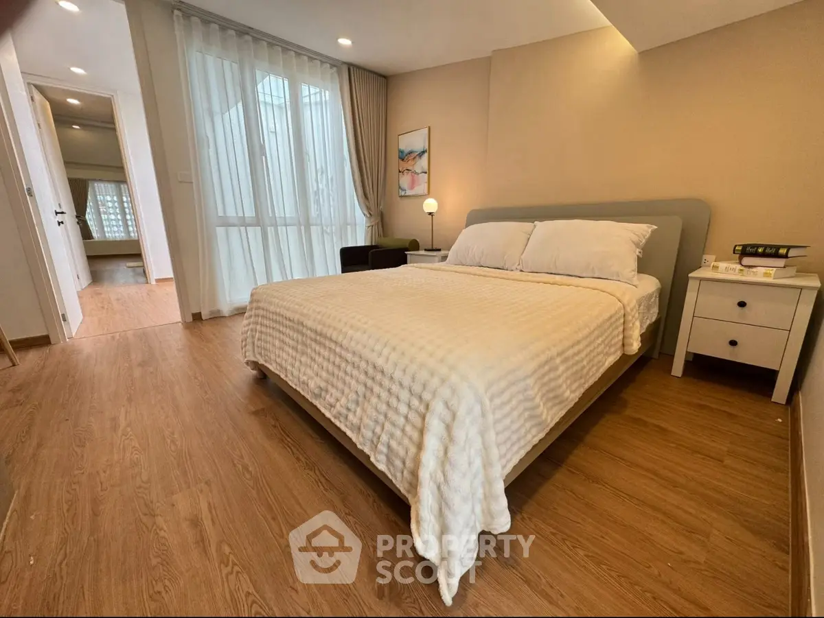 Spacious bedroom with modern decor and natural light, featuring a comfortable bed and stylish furnishings.