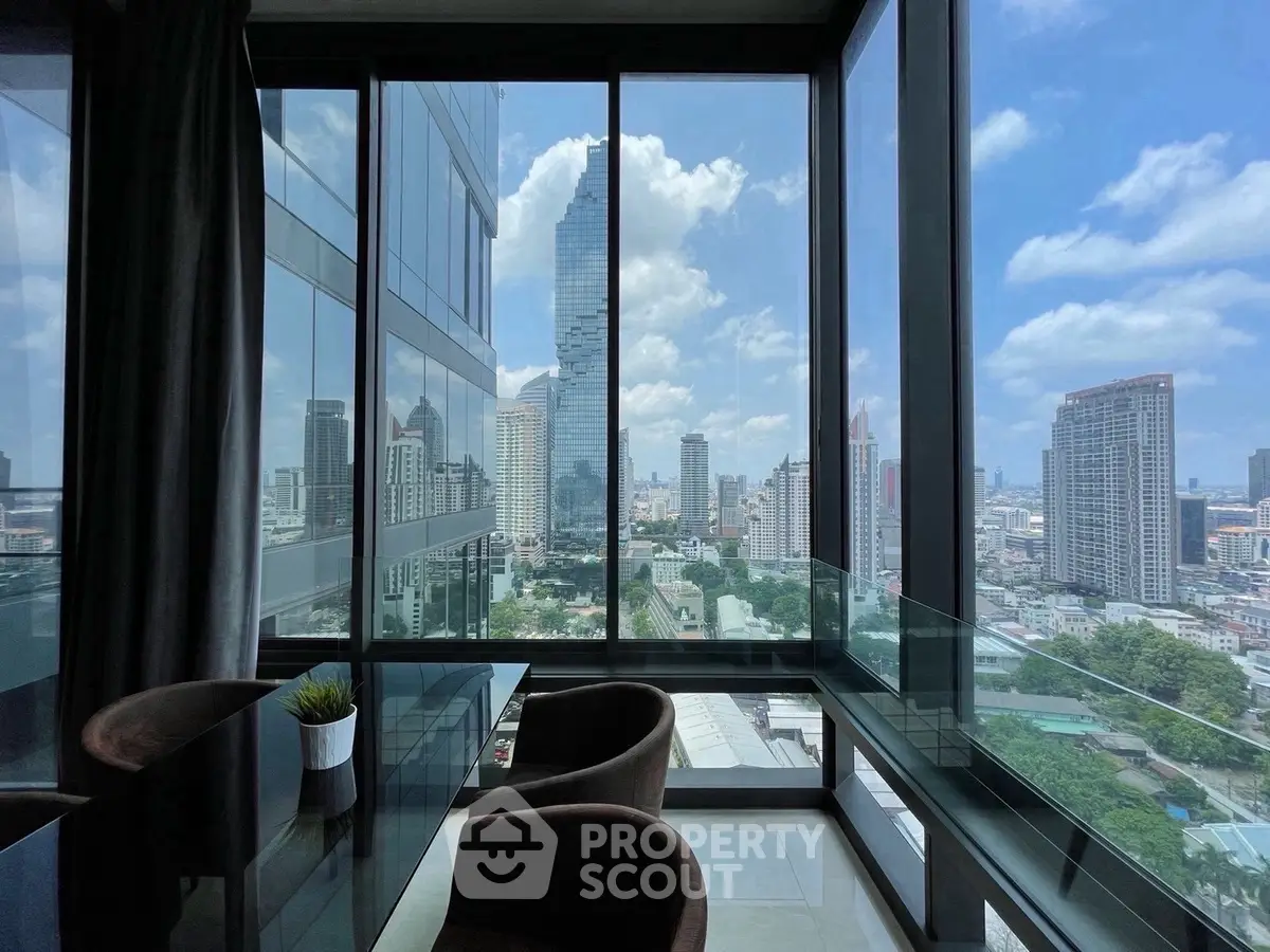 Stunning city view from modern high-rise apartment with floor-to-ceiling windows.