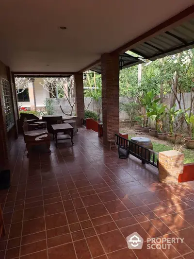 Spacious covered patio with garden view and outdoor seating area