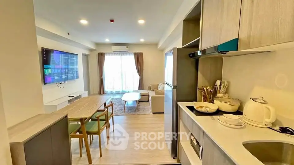 Modern open-plan living room and kitchen with stylish decor and natural light.