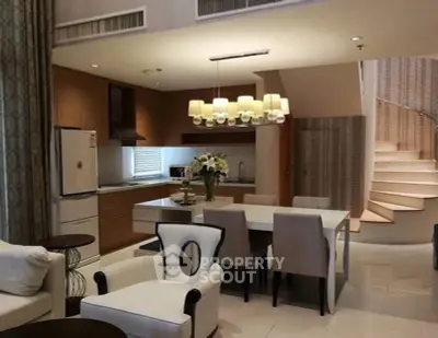 Luxurious open-plan kitchen and dining area with elegant staircase and modern decor