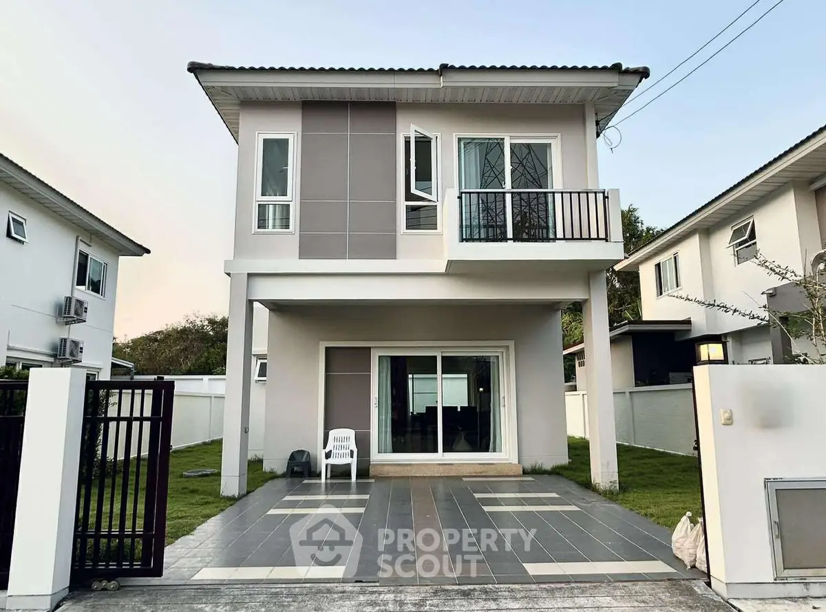 Modern two-story house with a small balcony and spacious driveway